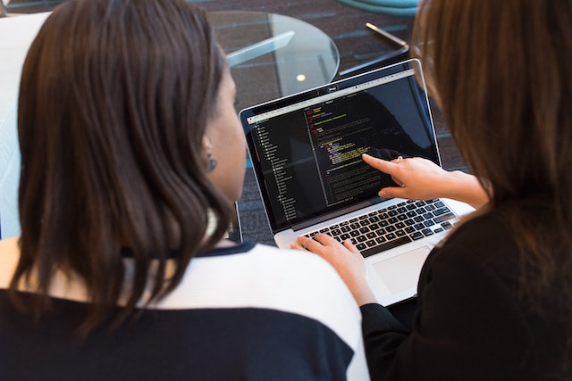 Woman writing code on computer